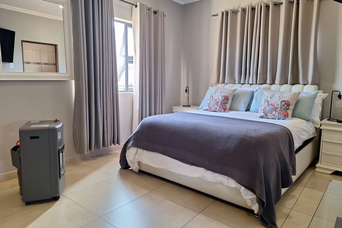 A well-maintained bedroom featuring neutral wall tones, tiled flooring, and decorative cornicing, providing a comfortable and clean living space.