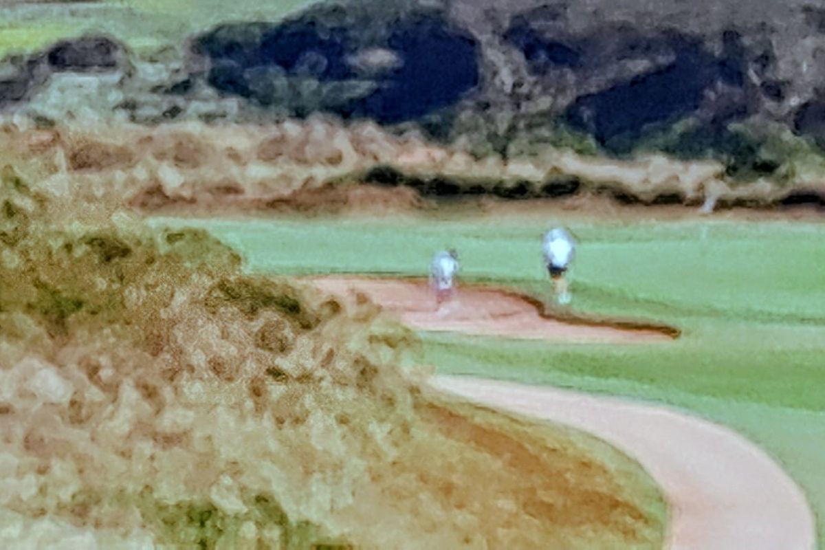 A view of a golf course fairway and sand bunker.