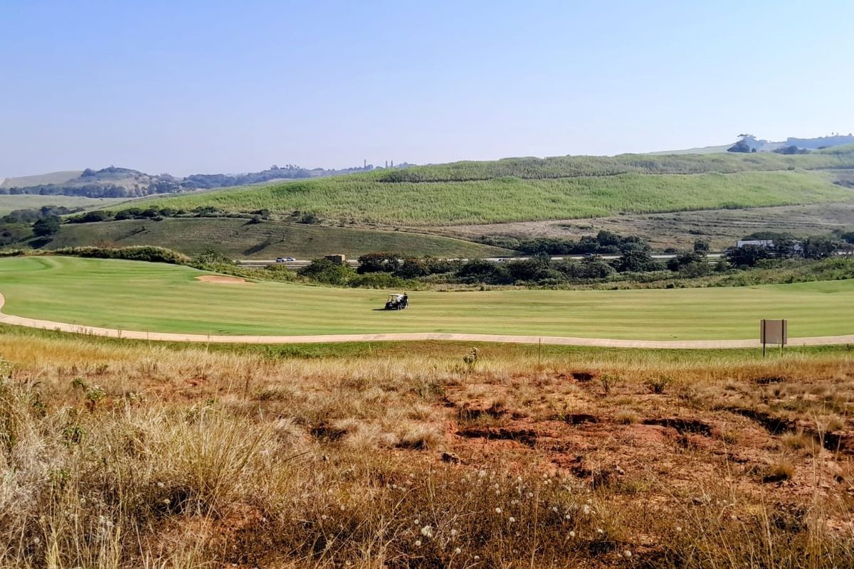 A scenic view overlooking a manicured golf course with rolling green hills in the background.
