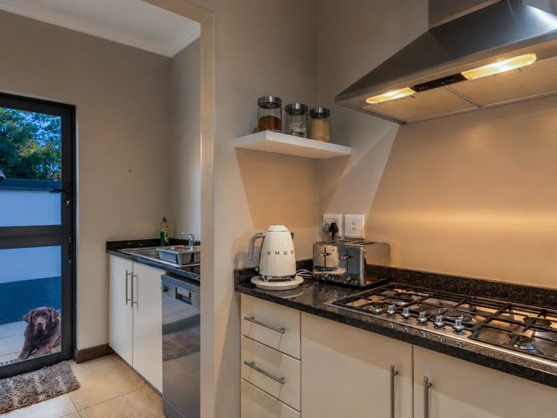 Modern kitchen featuring granite countertops, a gas hob with extractor fan, and direct access to an outdoor patio area.