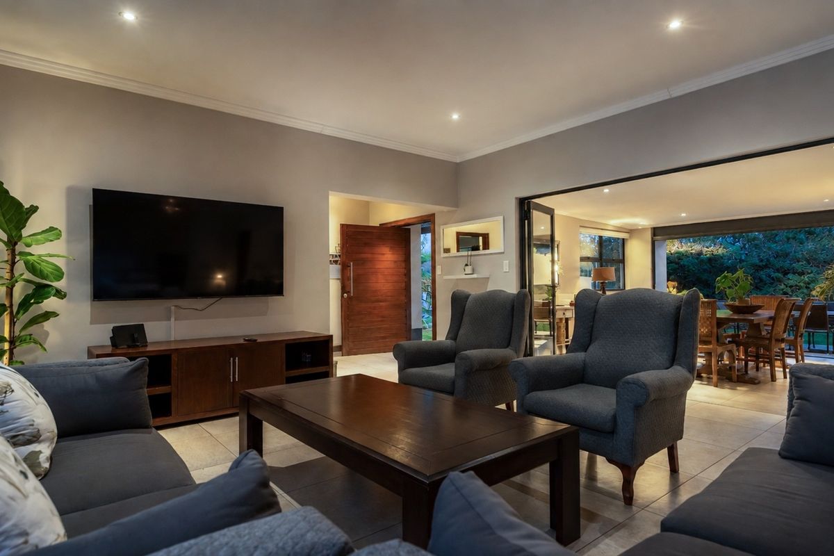 Spacious living room featuring tiled flooring, recessed downlighting, and large bi-fold doors providing seamless access to the outdoor patio area.