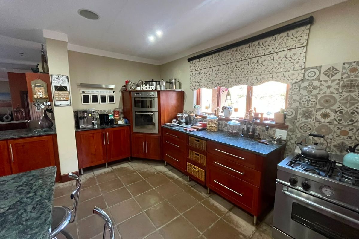 A functional kitchen featuring wooden cabinetry, built-in oven, gas cooktop, and decorative tiled backsplash with tiled flooring.