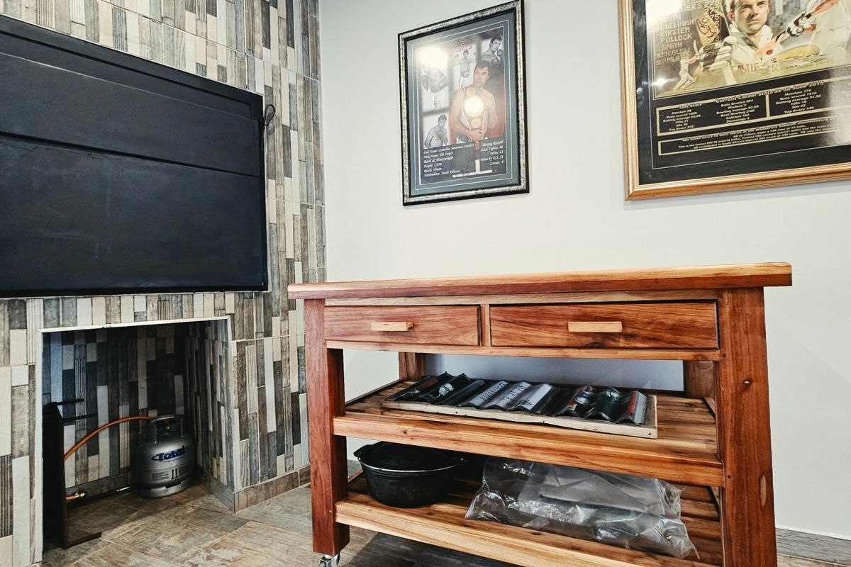 A living area featuring a built-in fireplace with a modern stone tile surround and tiled flooring.