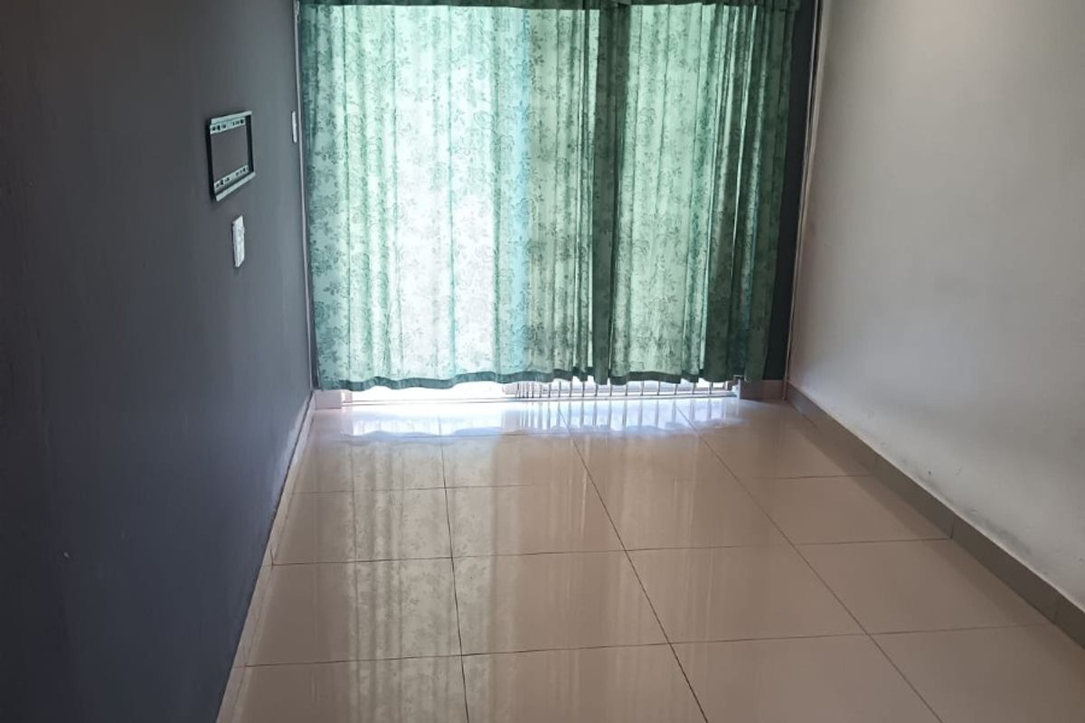 An empty living room featuring neutral tiled flooring, recessed downlighting, and a sliding glass door providing access to the exterior.