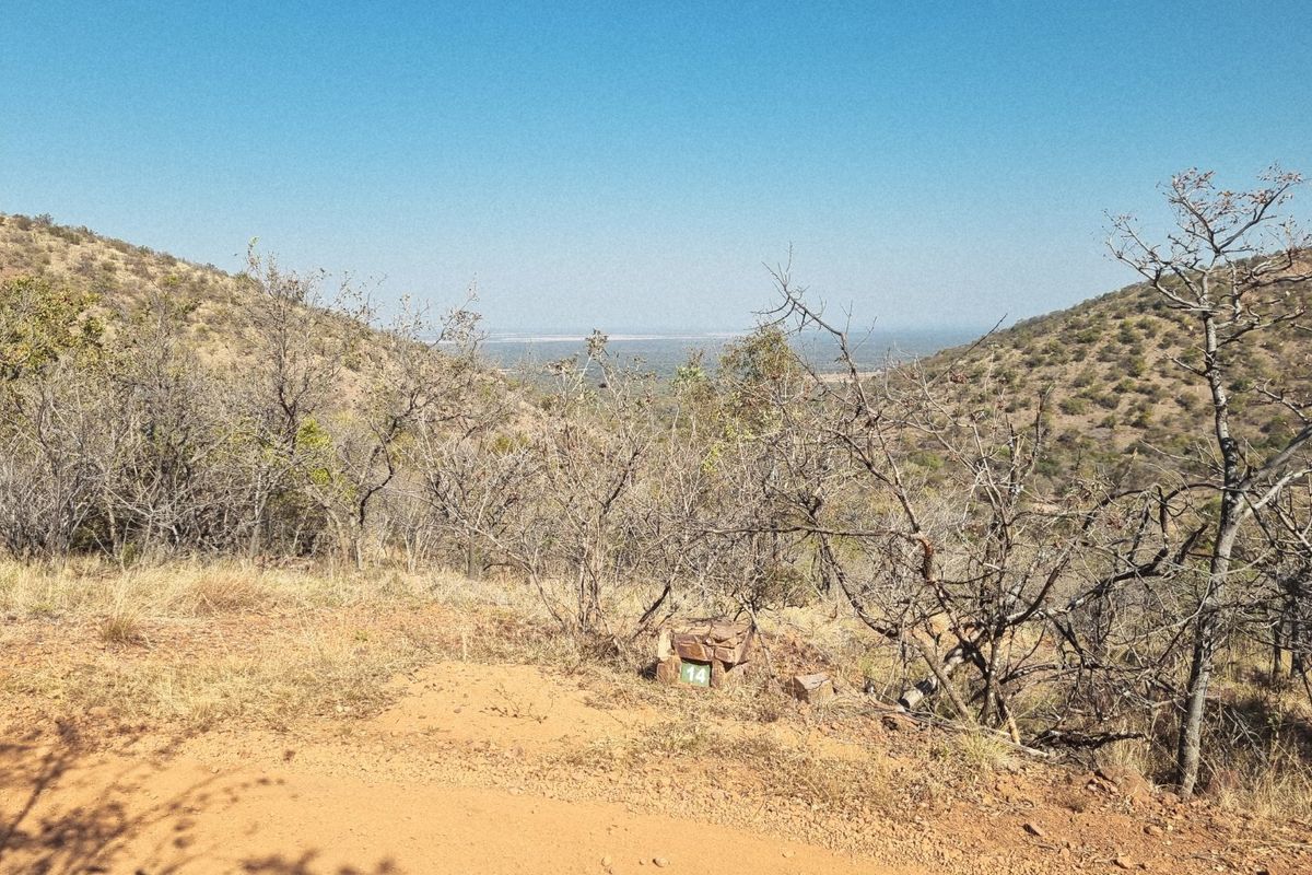 A scenic view overlooking the natural hillside landscape and surrounding terrain from the vacant residential plot.