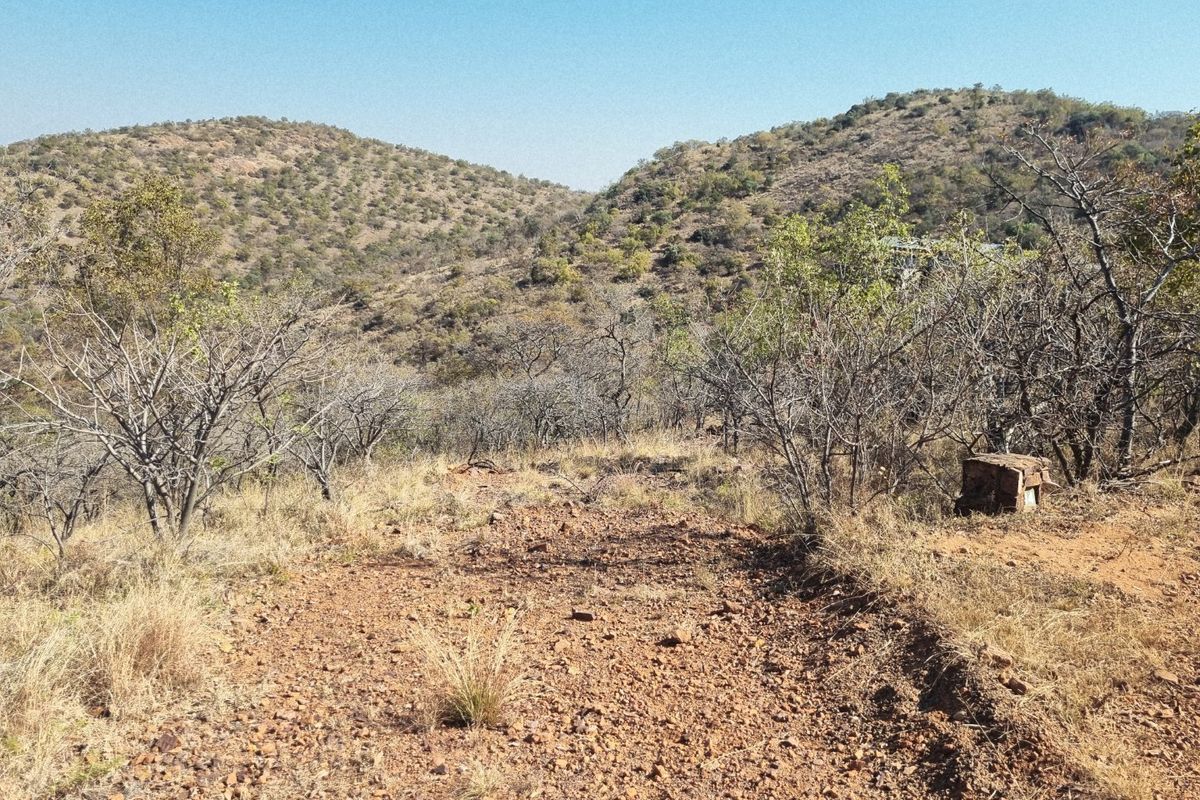 A scenic view of the natural hilly landscape and dry vegetation on the vacant residential property.