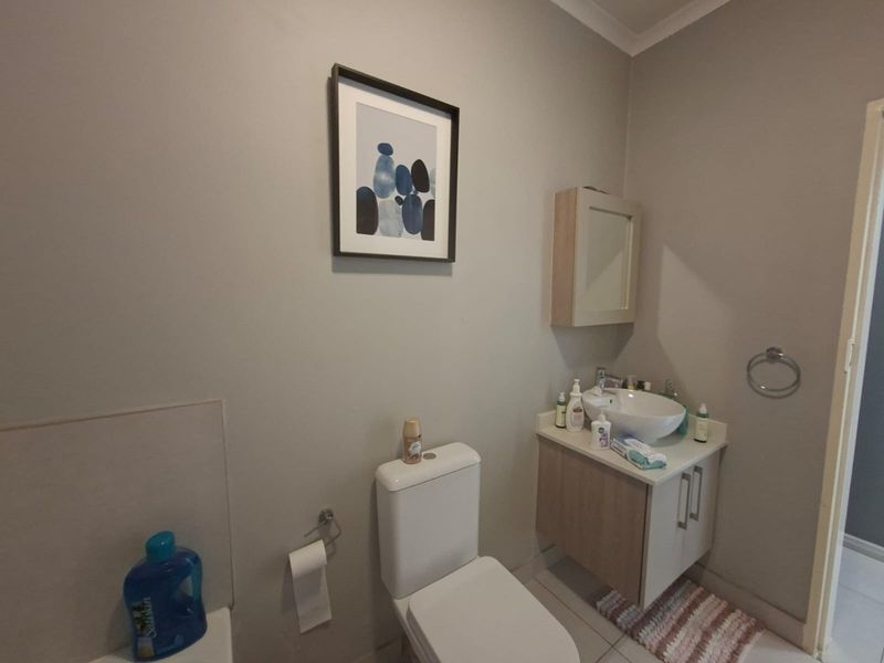 A functional bathroom featuring a modern vanity with a vessel sink, wall-mounted medicine cabinet, and a standard toilet.