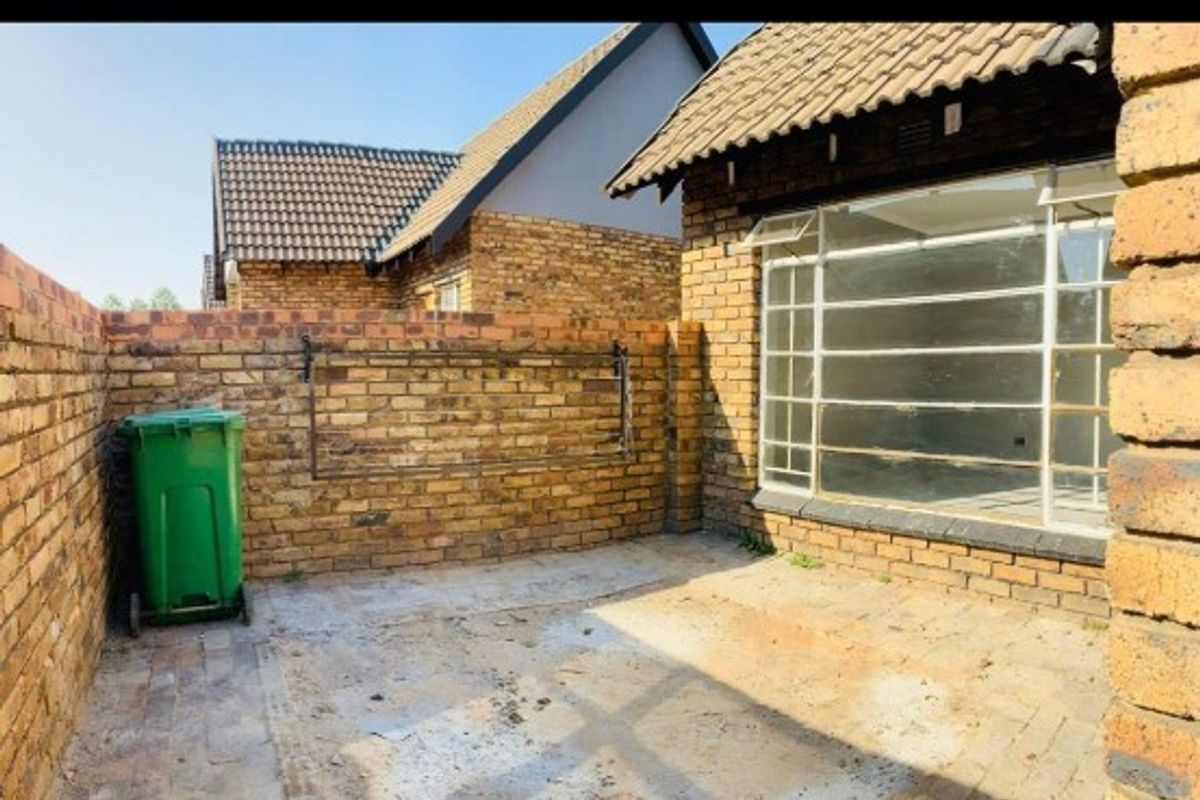A private rear courtyard featuring face brick walls and paved flooring, providing a blank canvas for outdoor landscaping or entertainment area development.