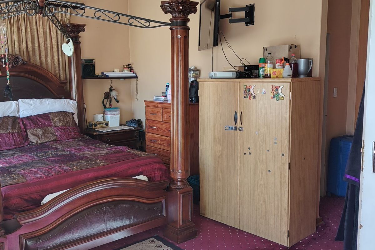 A bedroom featuring a four-poster bed frame and a wall-mounted television bracket.