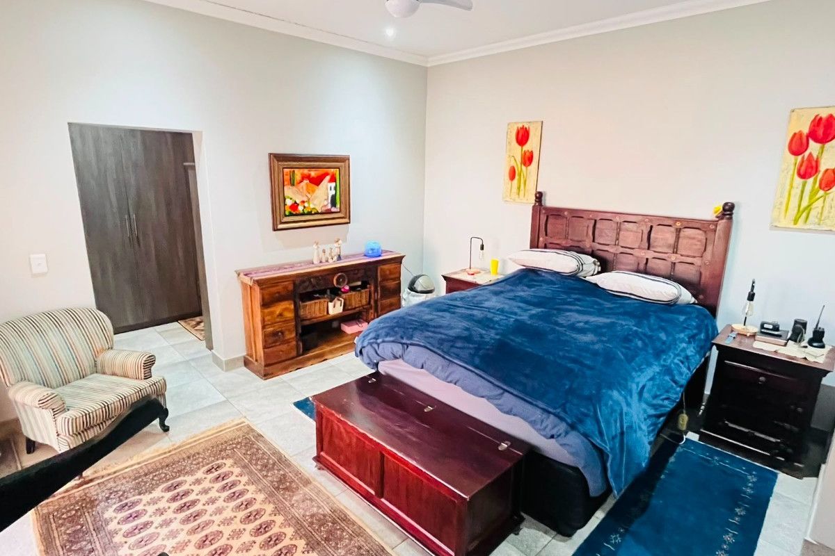 Spacious bedroom featuring tiled flooring, a ceiling fan, and built-in cupboards, offering a comfortable and functional living space.