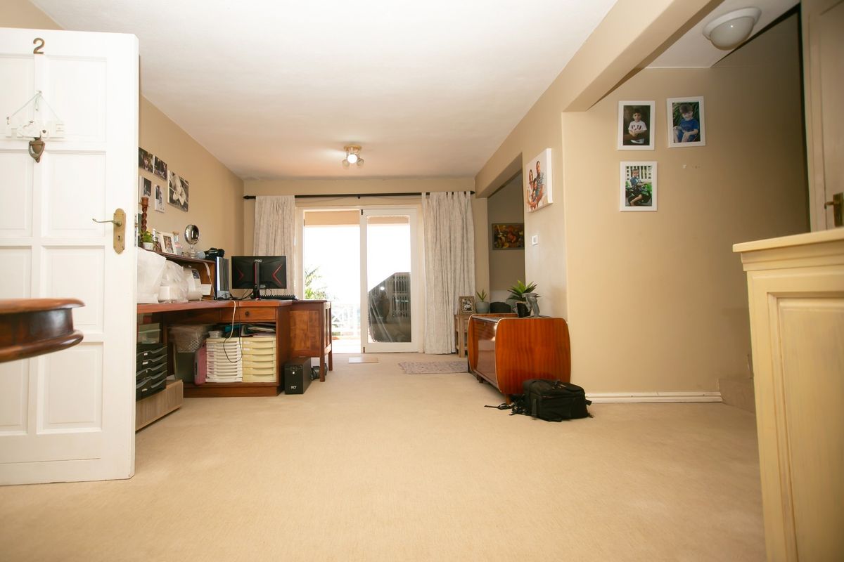 A living room area featuring neutral carpeting and a sliding glass door providing access to an outdoor space.