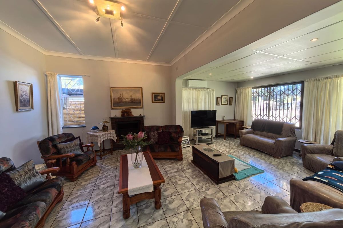 Spacious living room featuring tiled flooring, a fireplace, and a split-system air conditioner, offering a comfortable and functional layout.