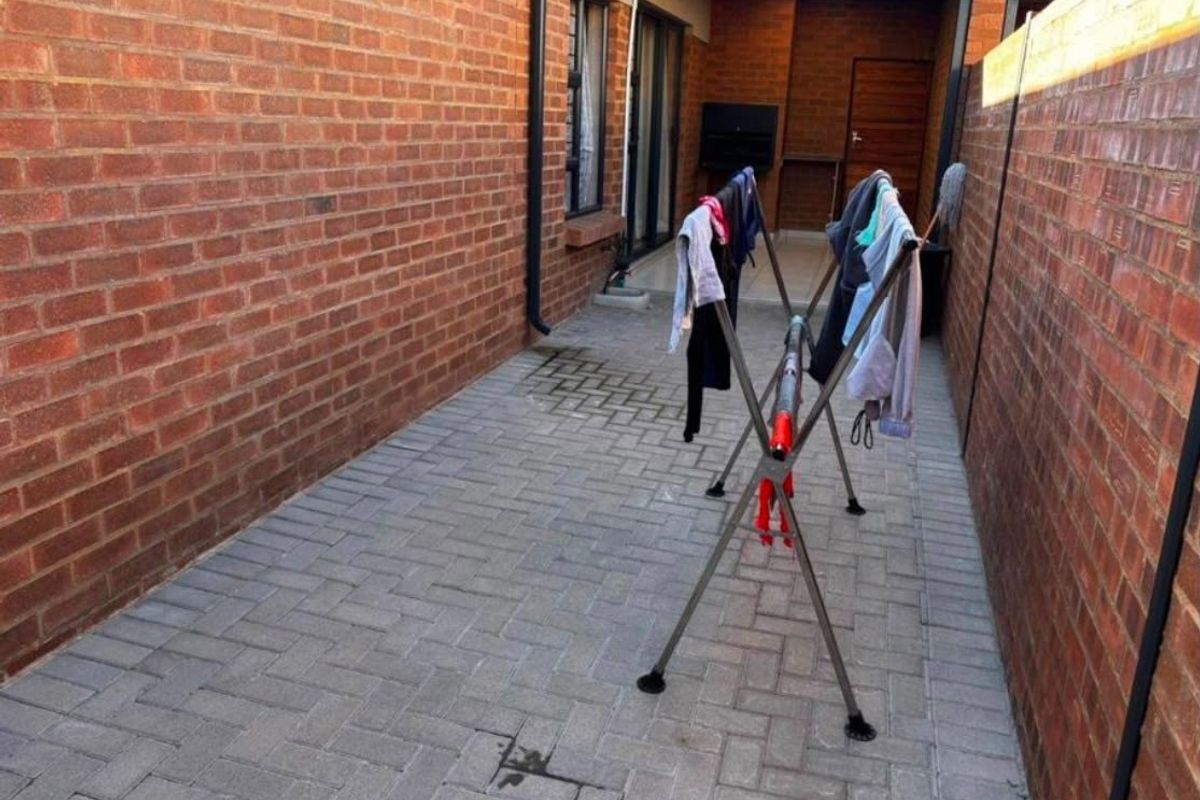 A private rear courtyard featuring brick boundary walls, paved flooring, and a built-in braai area, providing a functional outdoor space.