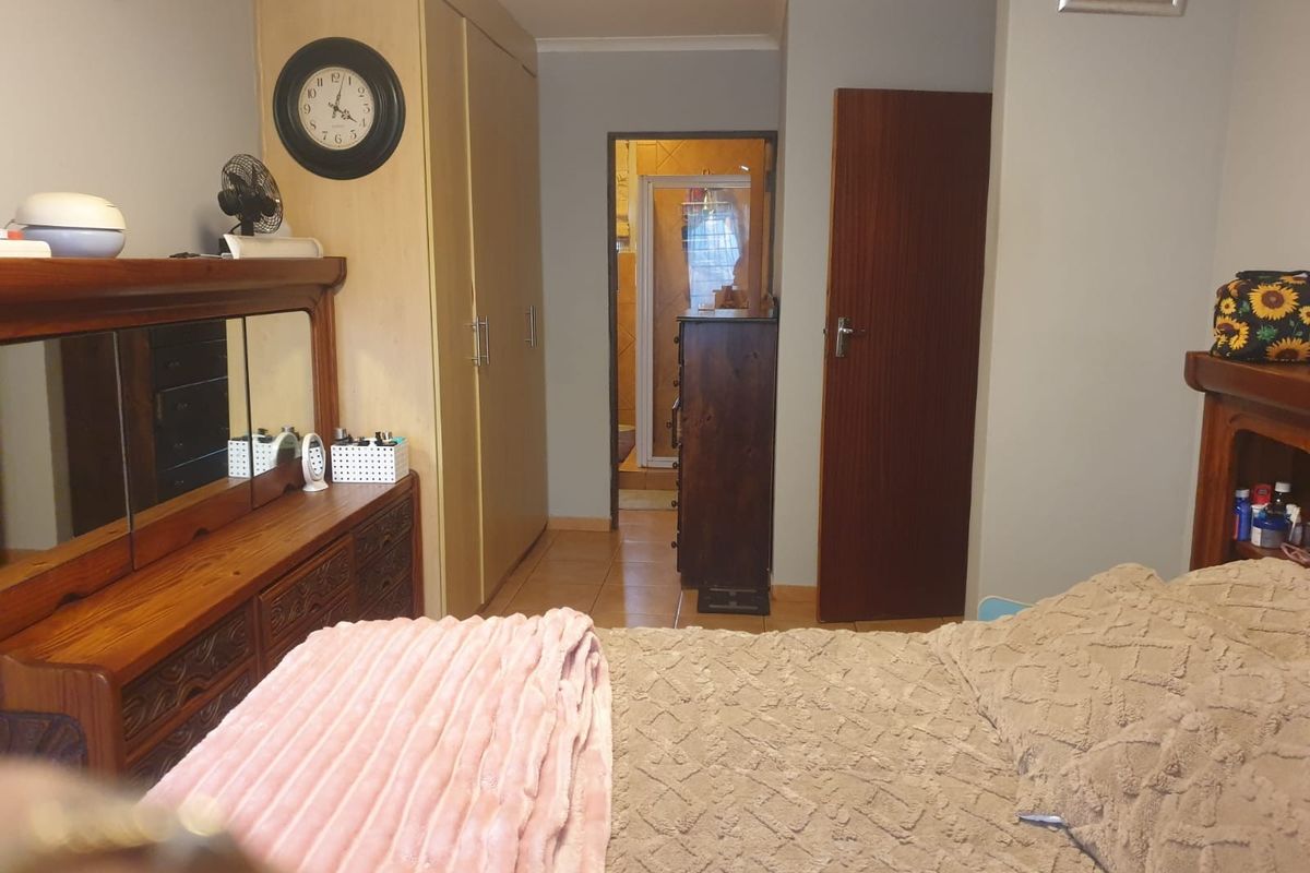 A bedroom featuring built-in cupboards, an air conditioning unit, and direct access to an en-suite bathroom.