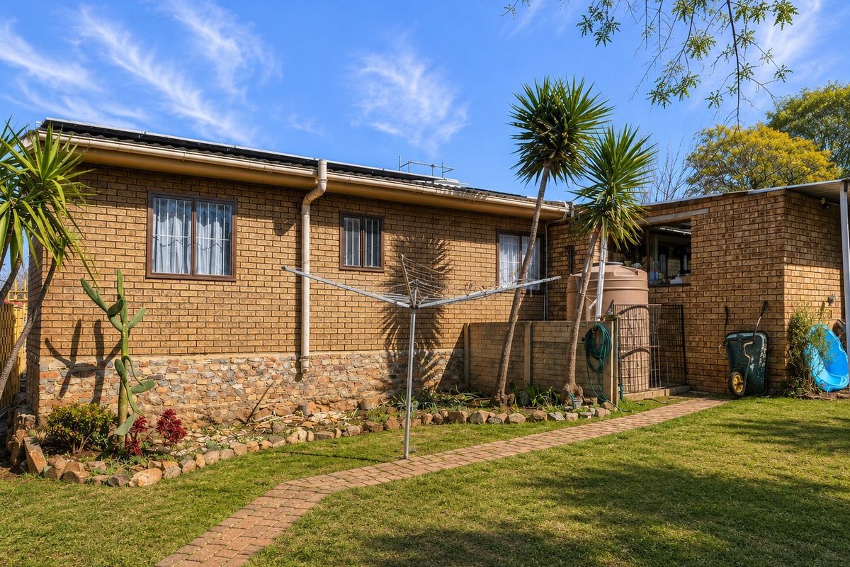 Rear view of the house featuring a face brick facade with stone cladding base, paved garden path, and an integrated water storage tank.