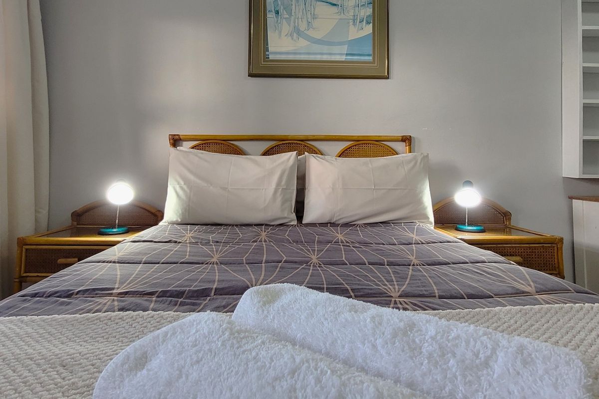 A cozy bedroom featuring neutral wall tones and convenient built-in shelving, providing a functional and comfortable sleeping space.