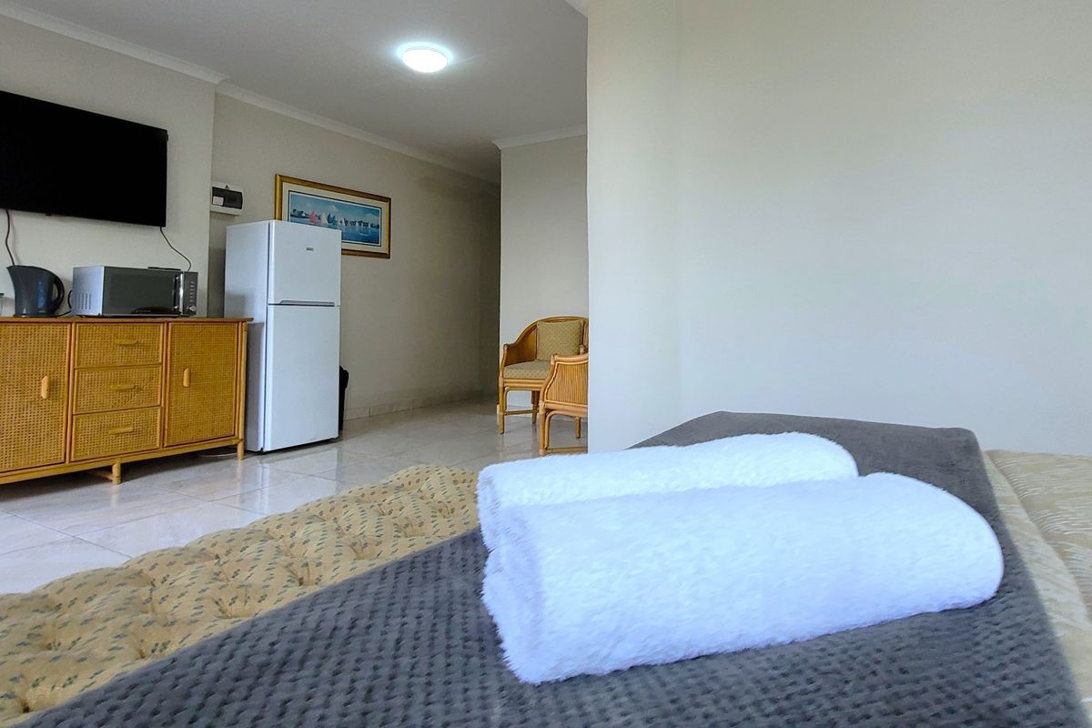 A bedroom featuring tiled flooring and recessed ceiling lighting, providing a functional space with neutral wall finishes.
