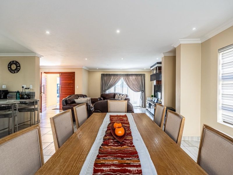 Spacious open-plan living and dining area featuring tiled floors, recessed lighting, and seamless flow between the kitchen and lounge spaces.