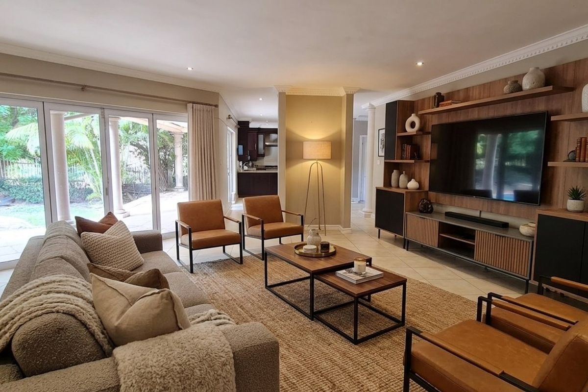 Spacious living room featuring built-in media cabinetry, tiled flooring, and large sliding glass doors providing seamless access to the outdoor patio area.