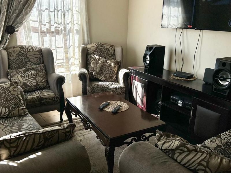A comfortable living room space featuring neutral wall finishes and natural light from the window.