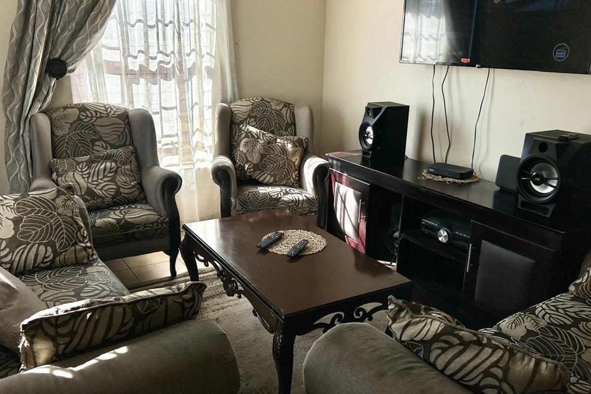 A comfortable living room space featuring neutral wall finishes and natural light from the window.