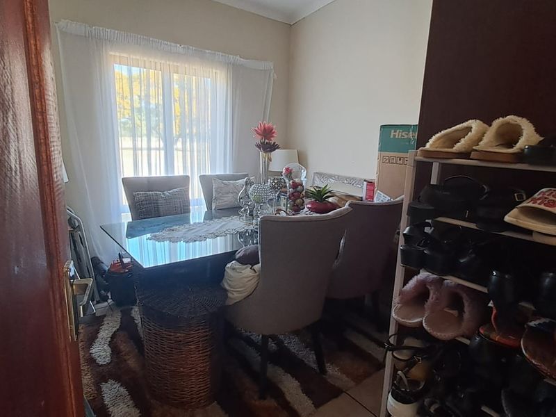 A dining room area featuring tiled flooring and a window, currently utilized as a multi-purpose space.