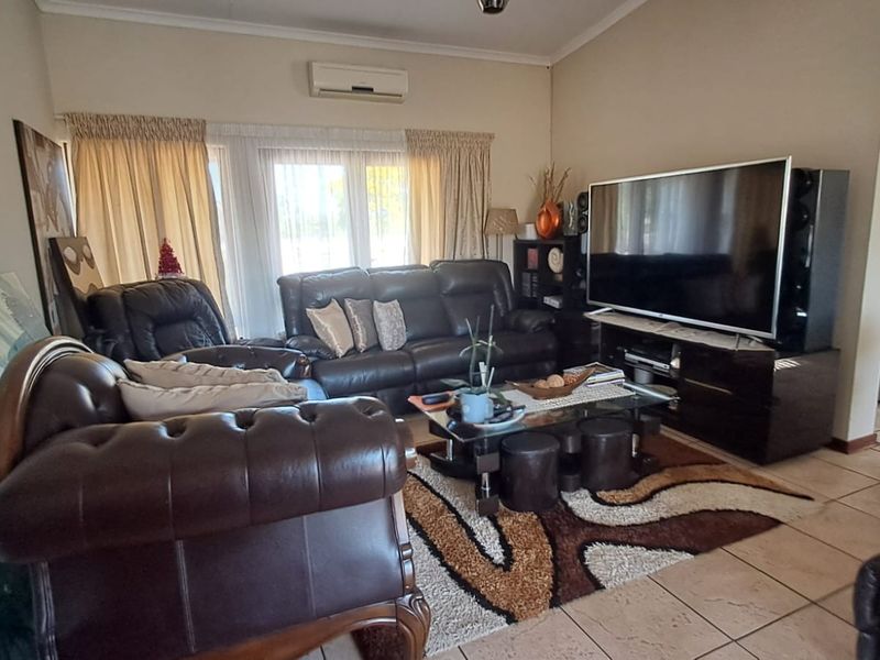 A comfortable living room featuring tiled flooring and a wall-mounted split-system air conditioner, providing a functional space for relaxation.