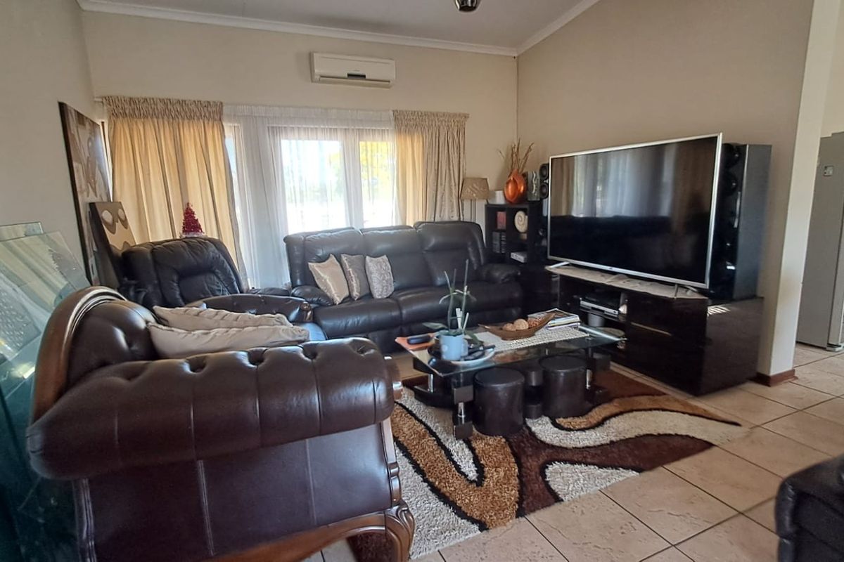 A comfortable living room featuring tiled flooring and a wall-mounted split-system air conditioner, providing a functional space for relaxation.