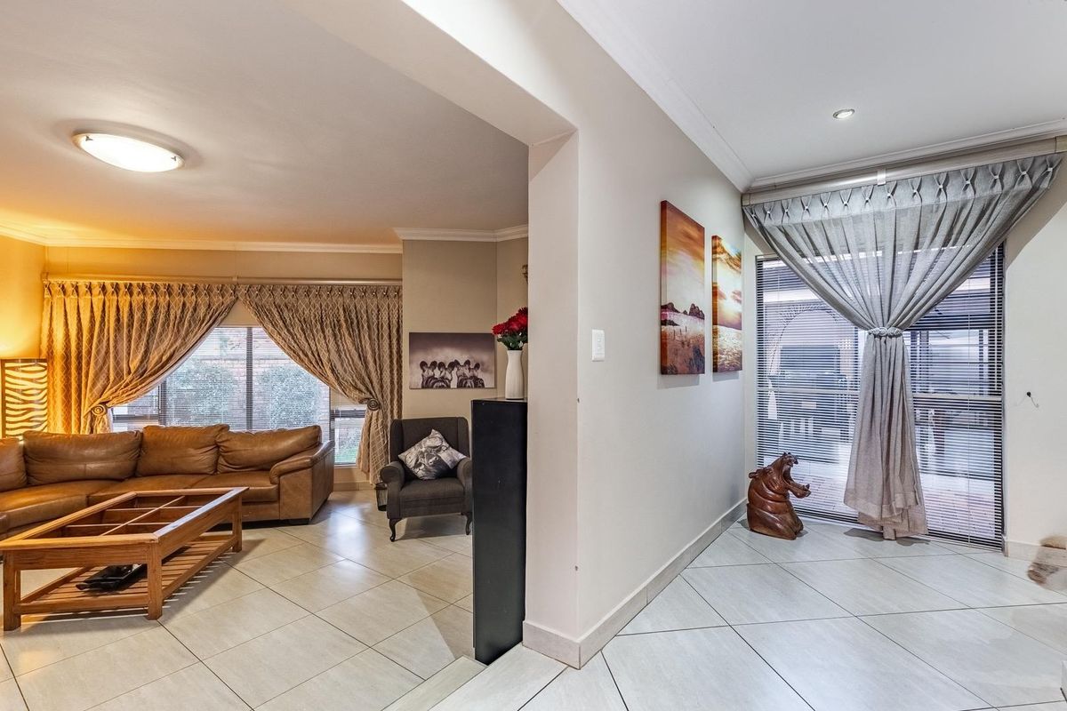 Spacious living area featuring neutral tiled flooring, recessed lighting, and large sliding glass doors providing natural light and access to the exterior.