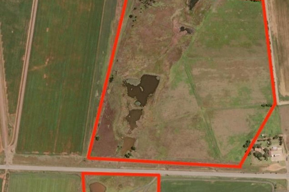 Aerial view of a large farm property featuring expansive agricultural land, multiple dams, and established access routes.