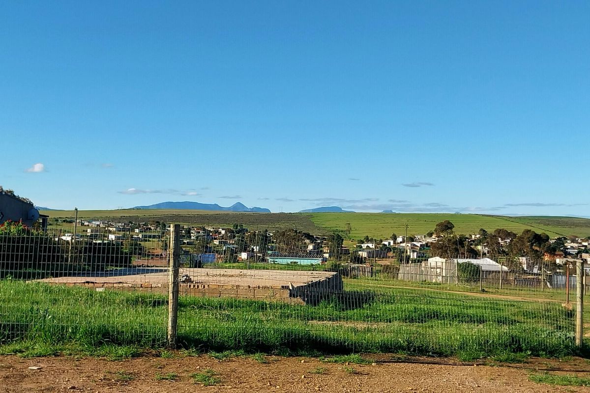 A view of the vacant residential land featuring a concrete foundation slab and wire mesh perimeter fencing, overlooking the surrounding landscape.
