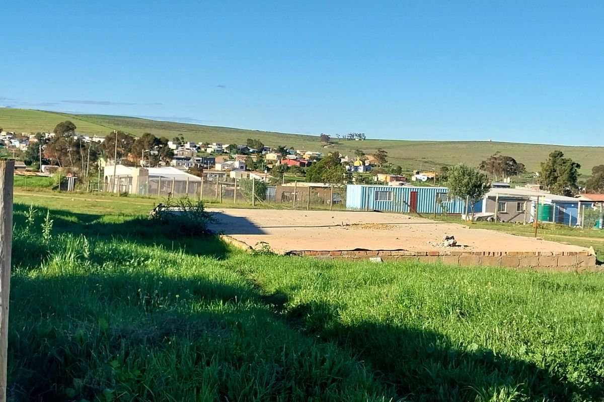 Vacant residential land featuring a concrete slab foundation and brick perimeter footing, situated in a developing neighborhood with surrounding landscape views.