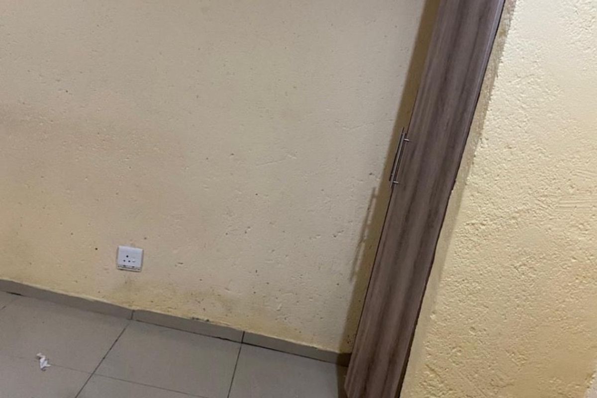 A vacant bedroom featuring tiled flooring and a built-in cupboard, requiring cosmetic updates to the walls.