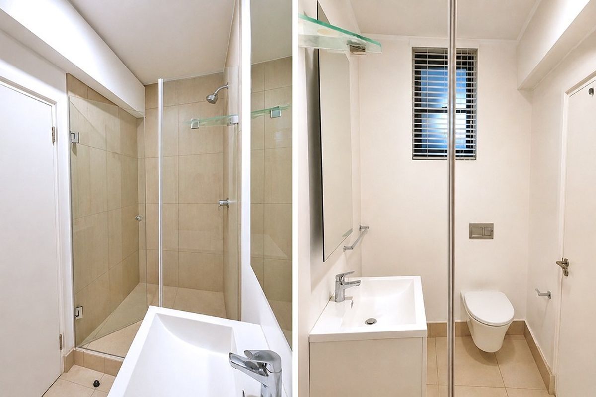 A modern, clean bathroom featuring a walk-in shower with glass screen, wall-hung toilet with concealed cistern, and a sleek vanity unit.
