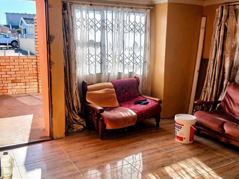 Living room featuring tiled flooring, decorative ceiling tiles, and direct access to an outdoor patio area through a sliding door.