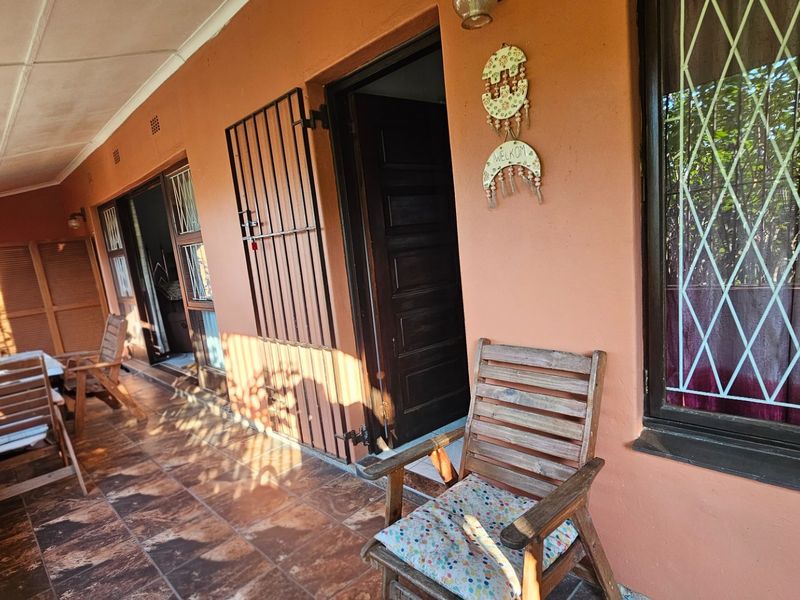 A covered patio area featuring tiled flooring and security fixtures, providing an outdoor transition space for the home.