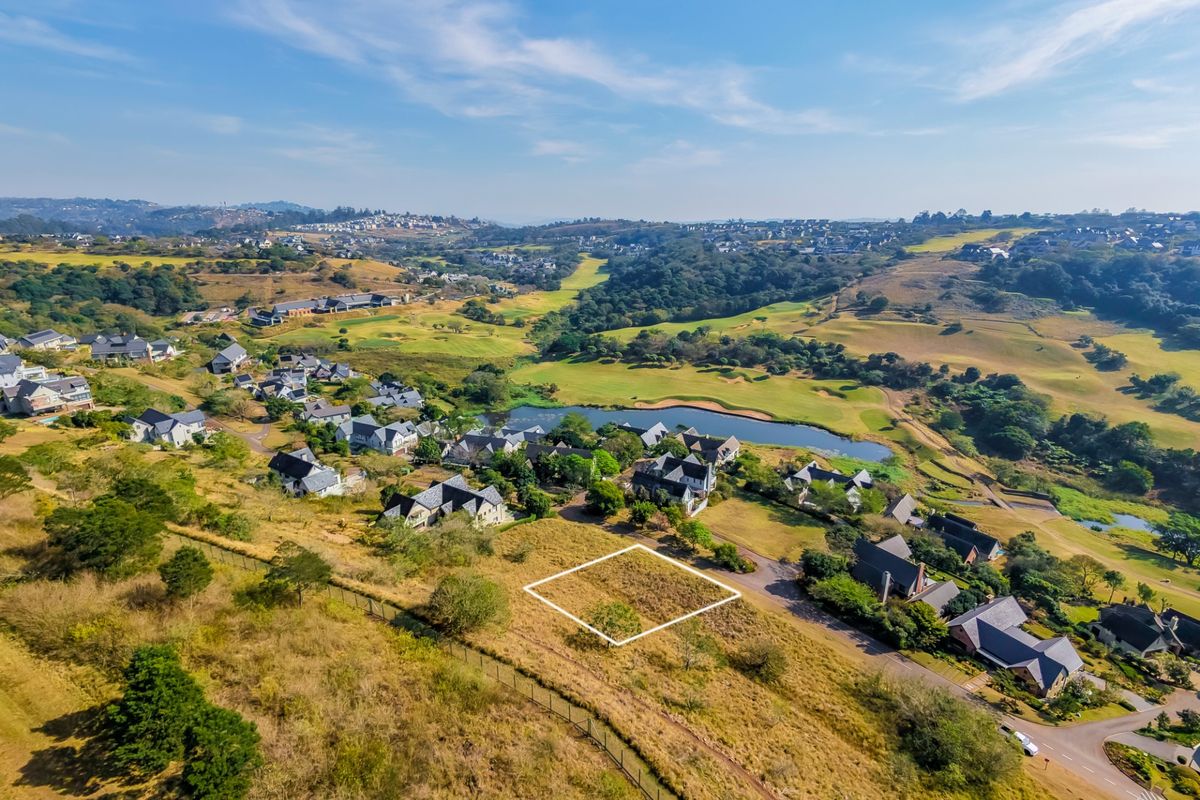 Aerial view of a vacant residential plot situated within a scenic estate, featuring surrounding greenery and established neighborhood infrastructure.