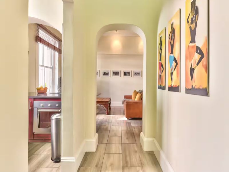 A bright hallway featuring tiled flooring and an elegant archway, providing a seamless transition between the living area and the adjacent kitchen space.