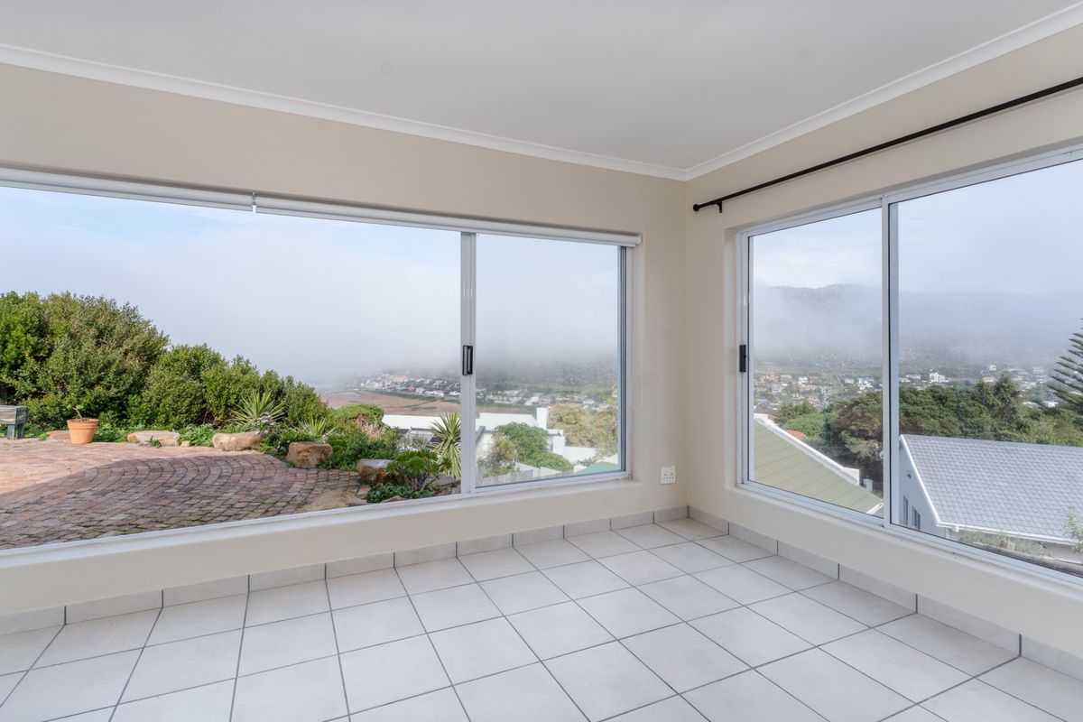 Bright and airy living space featuring expansive sliding glass windows that offer panoramic views and direct access to the outdoor patio area.