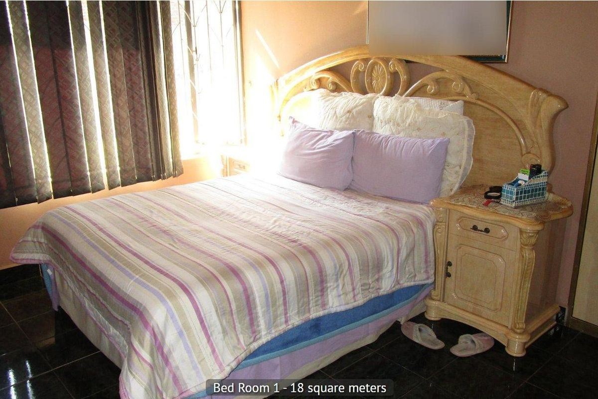 A bedroom featuring tiled flooring, a built-in wardrobe, and security bars on the window.