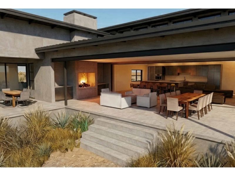 Spacious covered patio featuring a built-in fireplace, seamless indoor-outdoor flow, and direct access to the open-plan living and kitchen area.