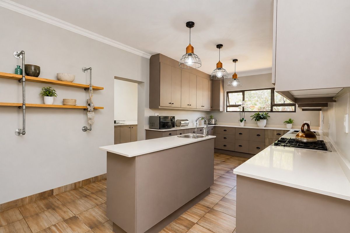 Modern kitchen featuring a central island, quartz countertops, gas hob, ample built-in cabinetry, and stylish pendant lighting with tiled flooring throughout.
