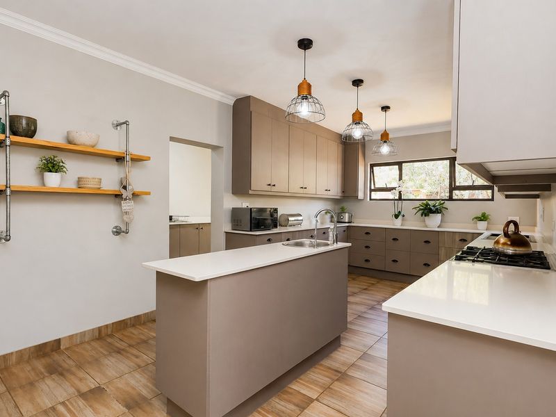 Modern kitchen featuring a central island, quartz countertops, gas hob, ample built-in cabinetry, and stylish pendant lighting with tiled flooring throughout.
