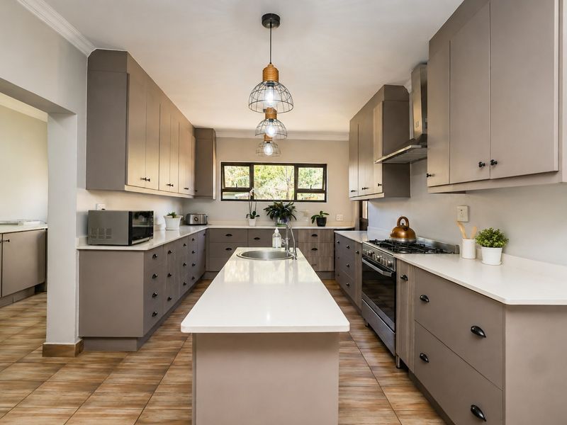 Modern kitchen featuring a central island, quartz countertops, ample built-in cabinetry, gas stove, and stylish pendant lighting with tiled flooring throughout.