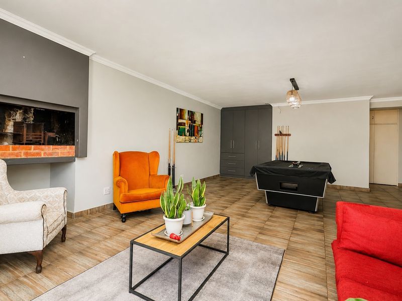 Spacious living area featuring a built-in fireplace, tiled flooring, and integrated storage cabinetry, offering a versatile space for relaxation and entertainment.