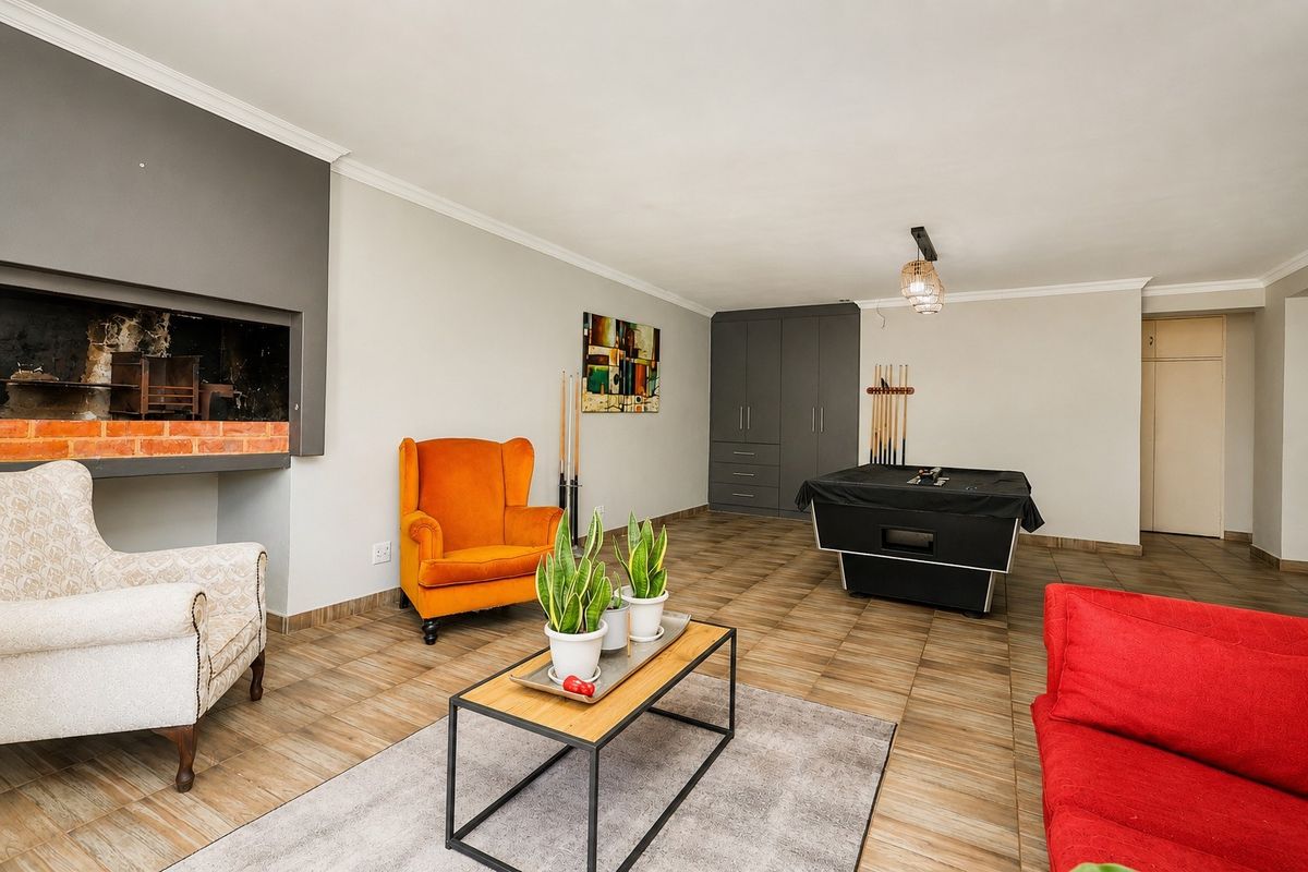 Spacious living area featuring a built-in fireplace, tiled flooring, and integrated storage cabinetry, offering a versatile space for relaxation and entertainment.