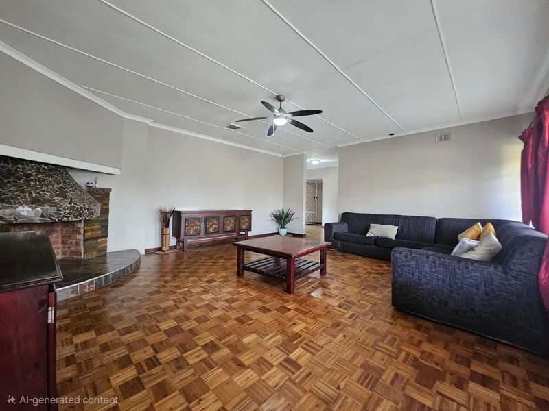 Spacious living room featuring classic parquet flooring, a prominent stone fireplace, and a ceiling fan, offering a warm and traditional atmosphere.