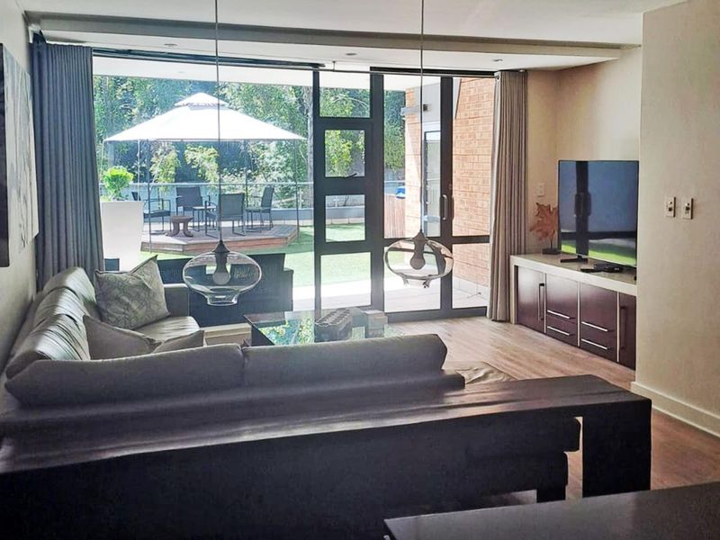 Spacious living room featuring large sliding glass doors that provide seamless access to an outdoor patio area and abundant natural light.