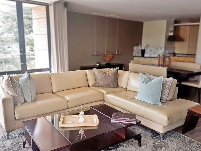 Spacious open-plan living area featuring modern kitchen cabinetry, large sliding glass doors for natural light, and high-quality hardwood flooring throughout.