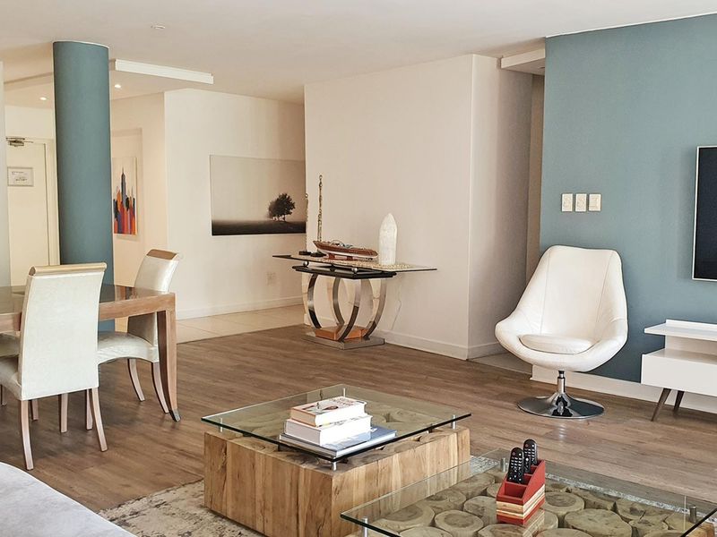 Spacious open-plan living and dining area featuring modern laminate flooring, a blue feature wall, and neutral finishes throughout.